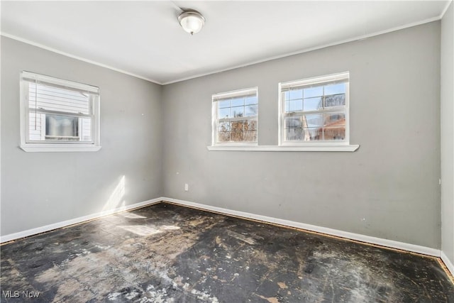 empty room featuring ornamental molding and baseboards