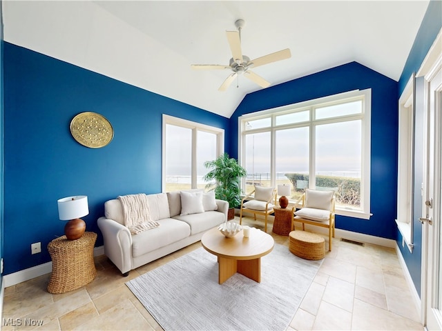 living area featuring lofted ceiling, baseboards, visible vents, and a ceiling fan