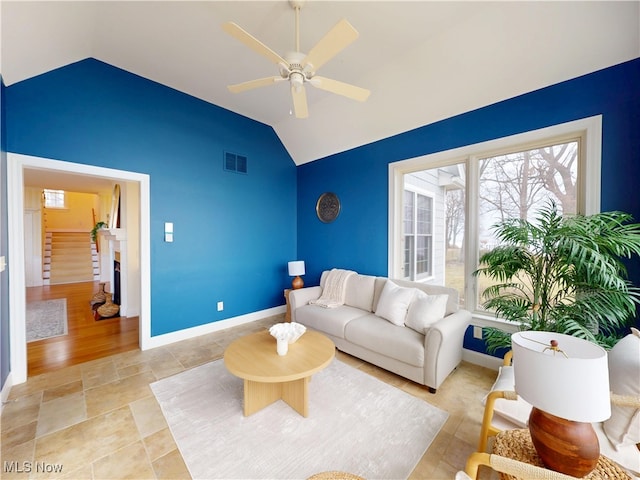 living room featuring baseboards, visible vents, a ceiling fan, lofted ceiling, and stairs