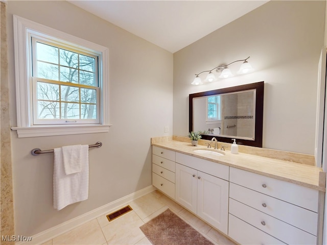 bathroom featuring visible vents, vanity, baseboards, and tile patterned floors