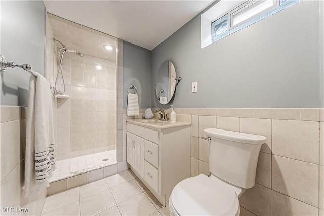 full bath with tile walls, toilet, a stall shower, vanity, and tile patterned flooring