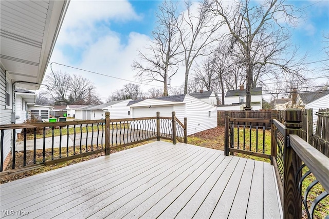 deck featuring a residential view, fence, and an outbuilding