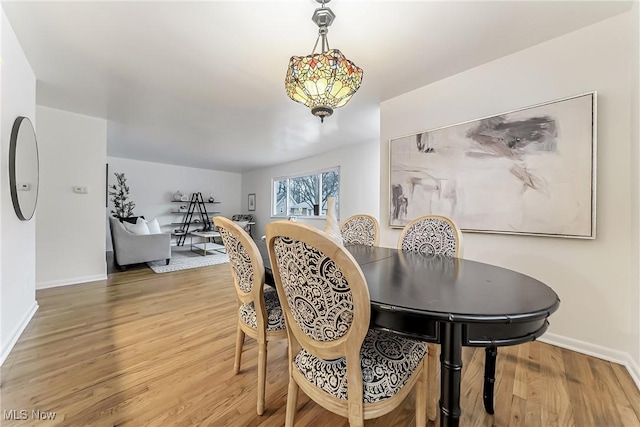 dining area featuring light wood-type flooring and baseboards