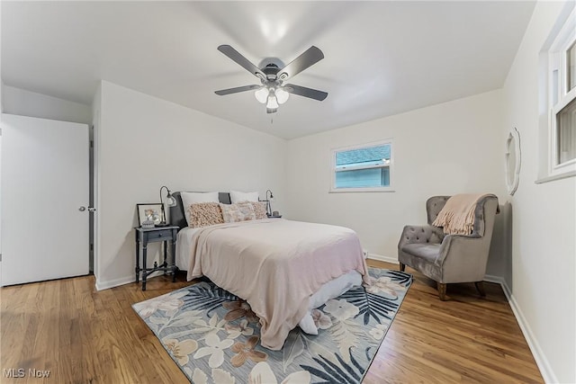 bedroom with light wood-style floors, ceiling fan, and baseboards