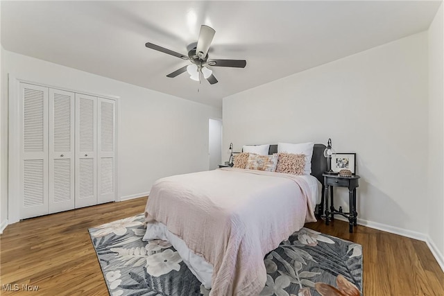 bedroom featuring ceiling fan, a closet, wood finished floors, and baseboards