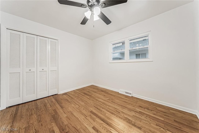 unfurnished bedroom featuring light wood-type flooring, baseboards, visible vents, and a closet