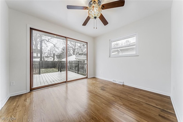 unfurnished room featuring visible vents, ceiling fan, baseboards, and wood finished floors