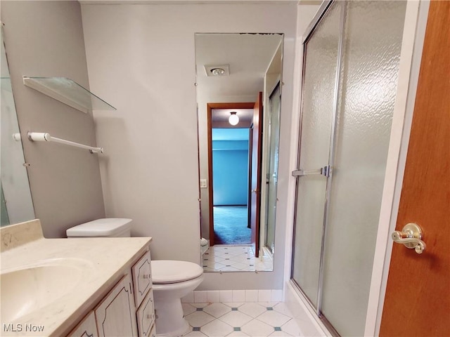 bathroom with toilet, a shower stall, visible vents, and vanity