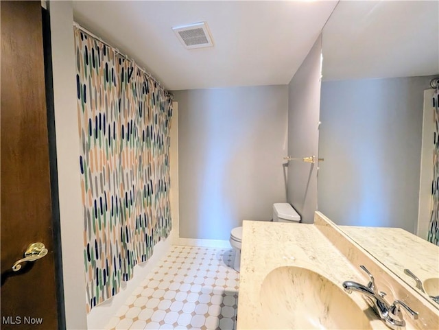 bathroom featuring toilet, a shower with shower curtain, visible vents, baseboards, and tile patterned floors