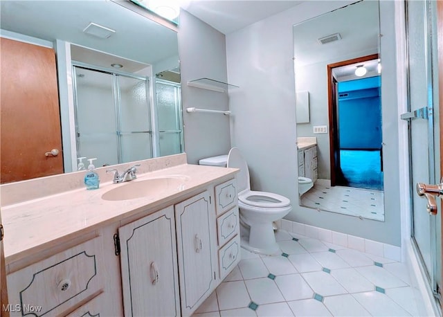 bathroom featuring toilet, a stall shower, visible vents, and vanity