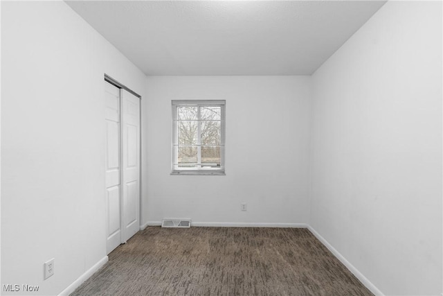 unfurnished bedroom with carpet, a closet, visible vents, and baseboards