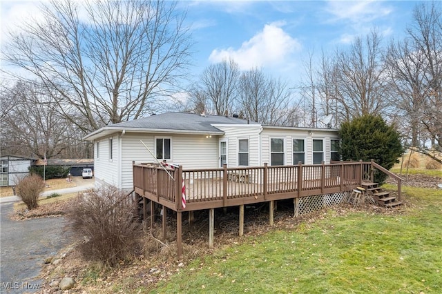 rear view of property with a yard and a deck