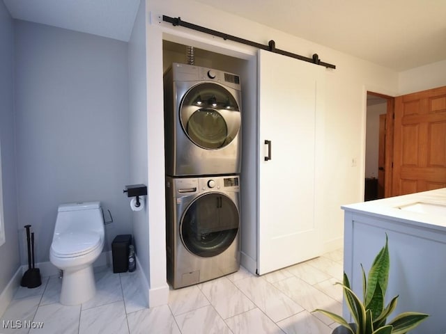 3945 Wheeler Creek Rd, Geneva, OH 44041 - washroom with a sink, stacked washing maching and dryer, a barn door, and marble finish floor