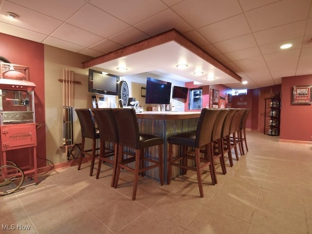 3945 Wheeler Creek Rd, Geneva, OH 44041 - bar featuring baseboards, a paneled ceiling, light tile patterned flooring, and bar area
