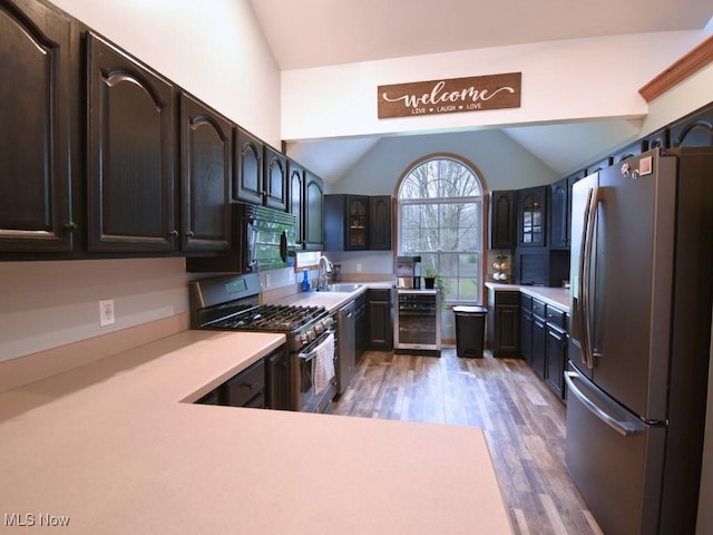 3945 Wheeler Creek Rd, Geneva, OH 44041 - kitchen featuring light countertops, appliances with stainless steel finishes, wine cooler, wood finished floors, and vaulted ceiling