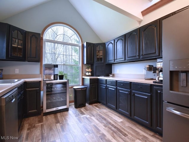 3945 Wheeler Creek Rd, Geneva, OH 44041 - kitchen featuring light countertops, light wood-type flooring, stainless steel appliances, beverage cooler, and lofted ceiling