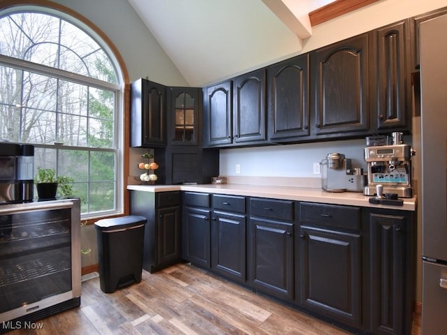 3945 Wheeler Creek Rd, Geneva, OH 44041 - kitchen featuring wine cooler, light countertops, light wood-style floors, and vaulted ceiling