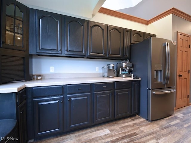 3945 Wheeler Creek Rd, Geneva, OH 44041 - kitchen featuring crown molding, stainless steel fridge with ice dispenser, glass insert cabinets, light wood-style flooring, and light countertops