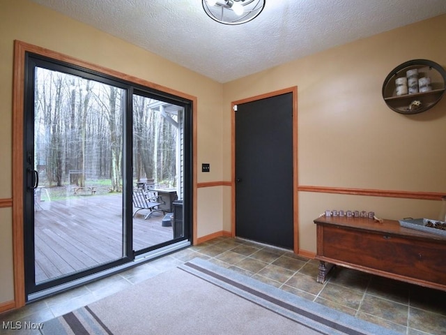 3945 Wheeler Creek Rd, Geneva, OH 44041 - doorway to outside featuring tile patterned floors, a textured ceiling, and baseboards