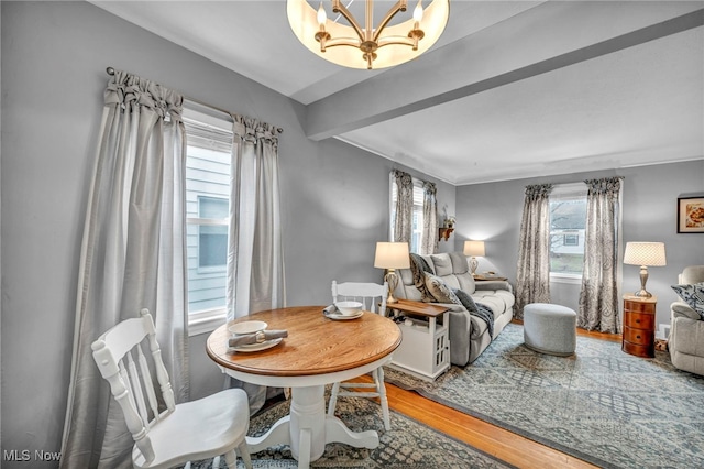 interior space featuring beamed ceiling, wood finished floors, and an inviting chandelier