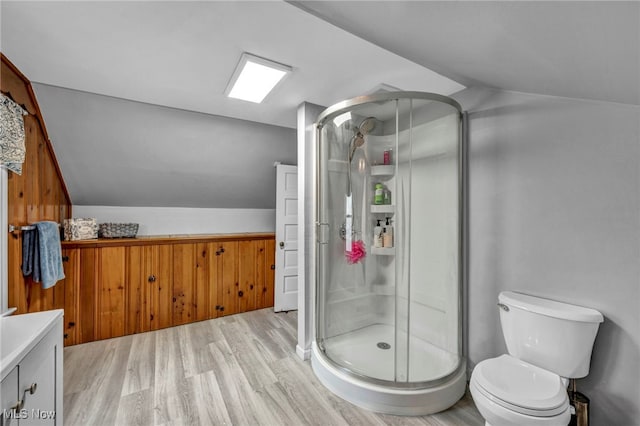 full bath featuring vaulted ceiling, a shower stall, and wood finished floors