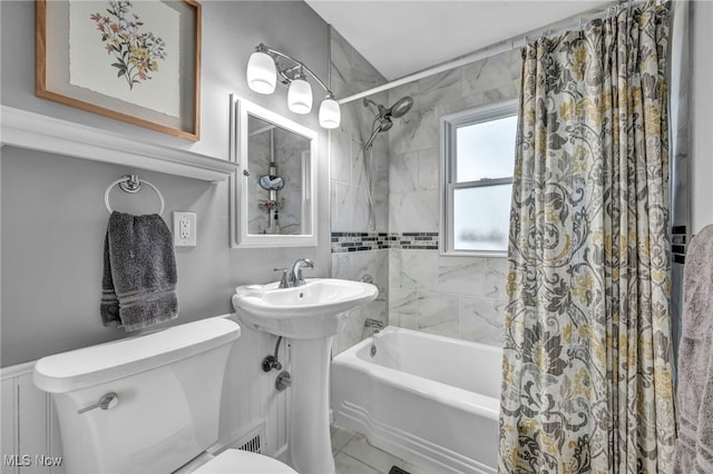 full bathroom featuring toilet, a sink, and shower / bath combination with curtain