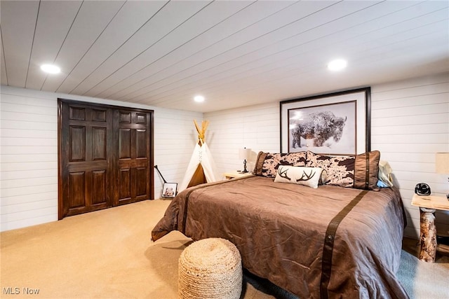 carpeted bedroom featuring wooden walls and recessed lighting