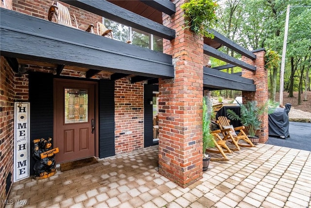 entrance to property featuring brick siding