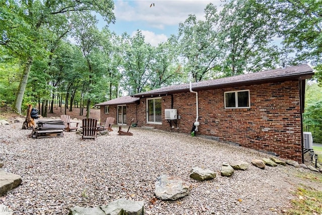 back of house with crawl space, a patio area, central AC, and brick siding