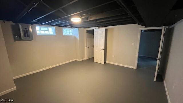 basement featuring electric panel and baseboards