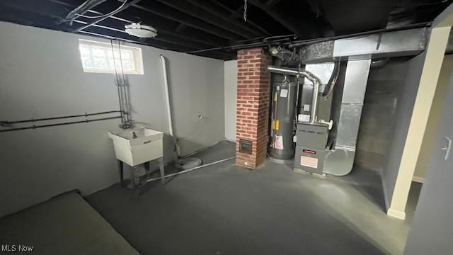 basement with water heater, a sink, and heating unit