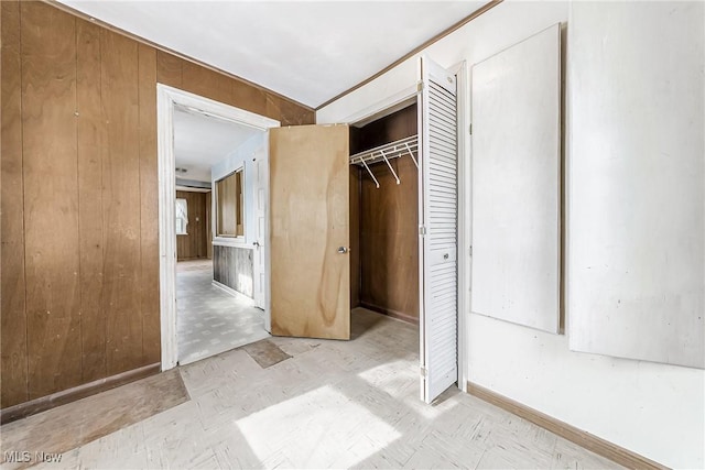 unfurnished bedroom with wood walls, a closet, and tile patterned floors