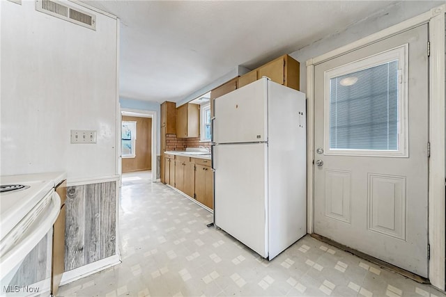 kitchen with light floors, light countertops, visible vents, a sink, and white appliances