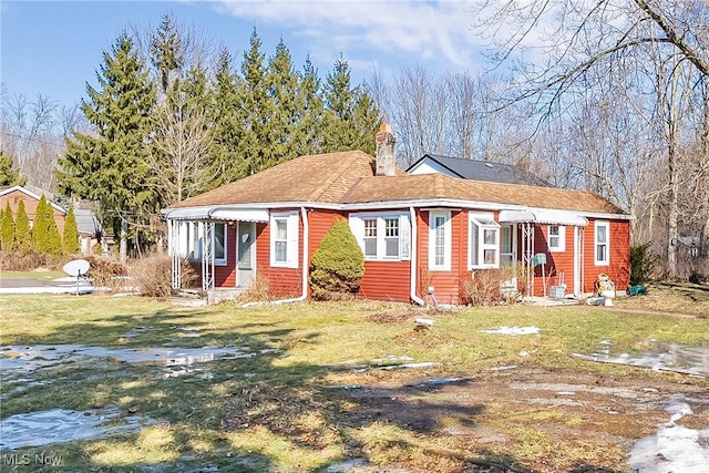 view of front of house featuring a chimney and a front lawn