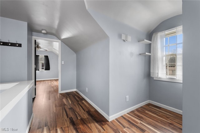 bonus room with vaulted ceiling, dark wood finished floors, and baseboards