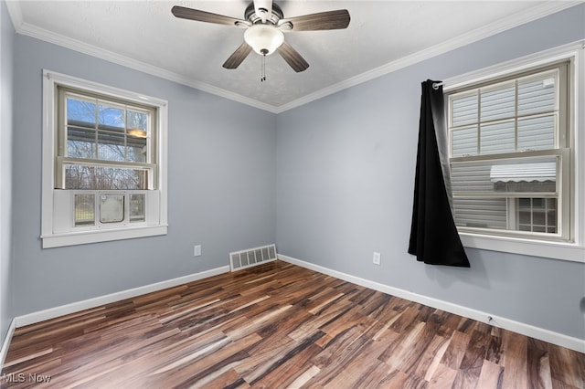 empty room with baseboards, visible vents, and wood finished floors