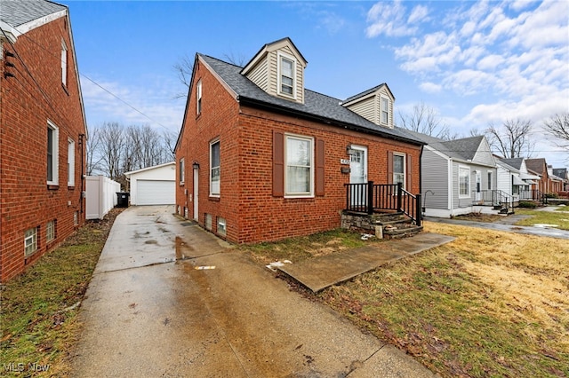 view of front of home with brick siding, an outdoor structure, a detached garage, and roof with shingles