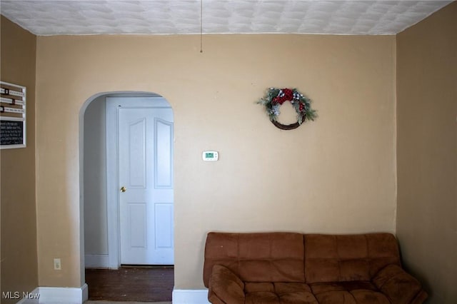 living room with arched walkways and baseboards