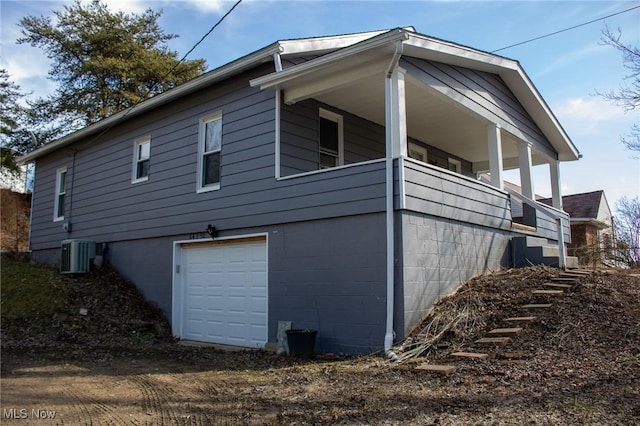 view of side of home featuring a garage and cooling unit