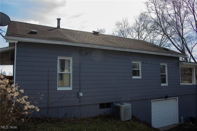 view of property exterior with a garage, a shingled roof, and cooling unit