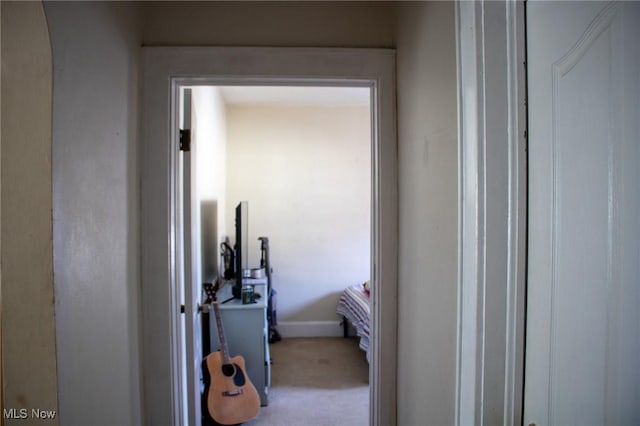 hallway with carpet flooring and baseboards