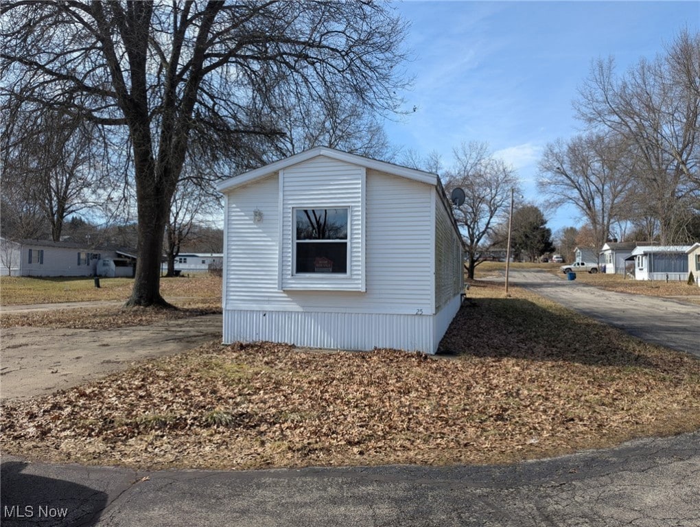 view of side of property with an outbuilding and driveway