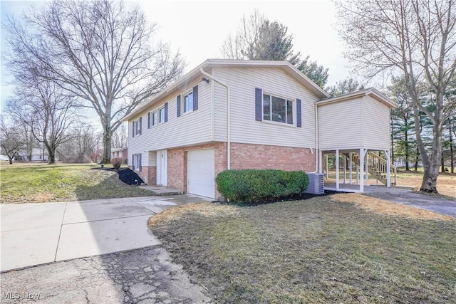 view of home's exterior featuring brick siding, driveway, stairway, and central air condition unit