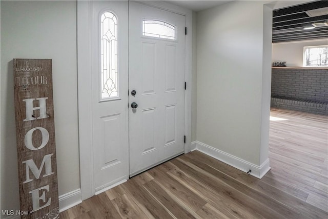 foyer entrance featuring baseboards and wood finished floors