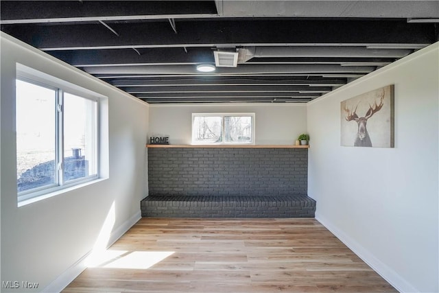 basement with baseboards and wood finished floors