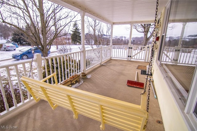 snow covered deck featuring a porch