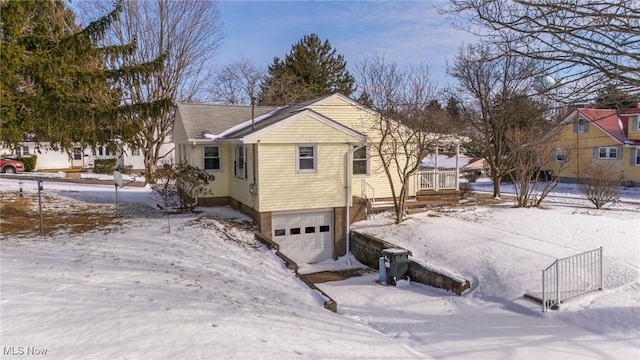 view of snowy exterior with an attached garage