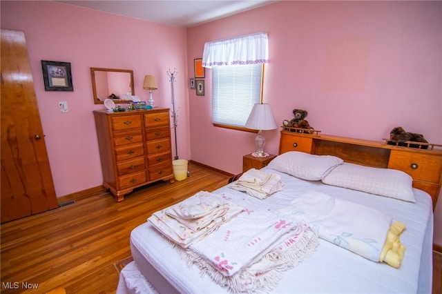 bedroom featuring wood finished floors and baseboards