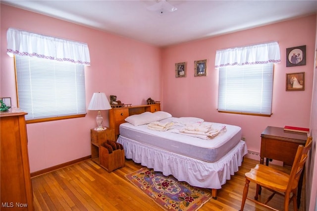 bedroom featuring baseboards and wood finished floors