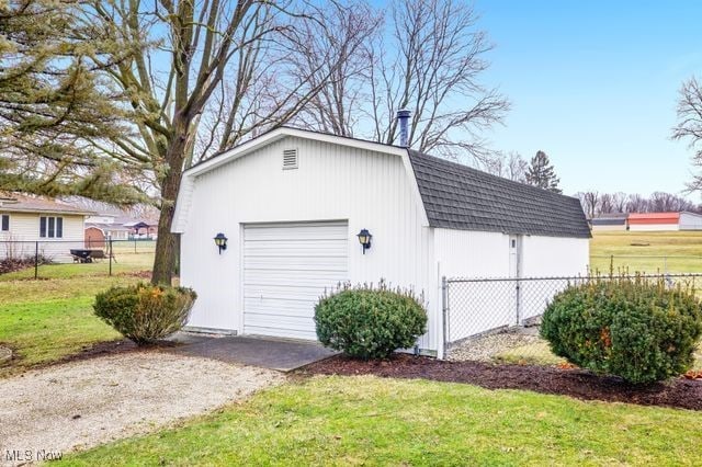 detached garage with fence and driveway